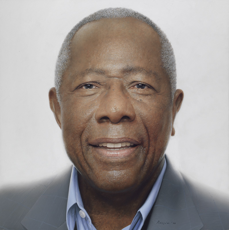 close-up head view of a middle-aged Black man in a gray jacket and blue shirt