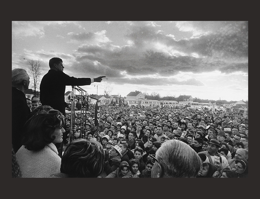 A man (JFK) addressing a large crowd