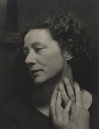 Sepia tone photograph of a woman with her hands on her neck