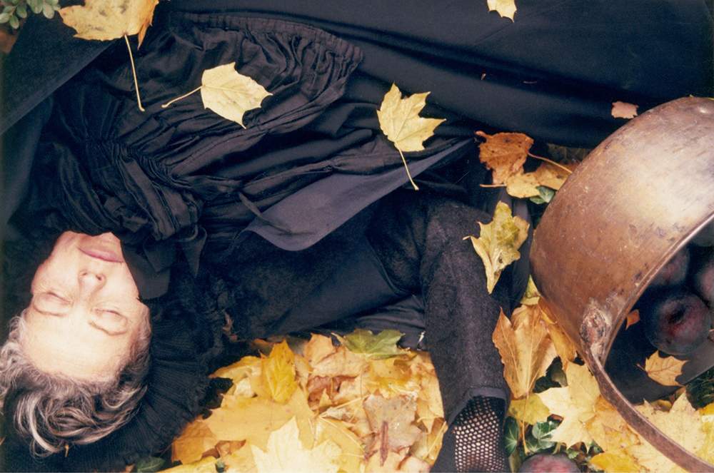 woman covered in black fabric and leaves