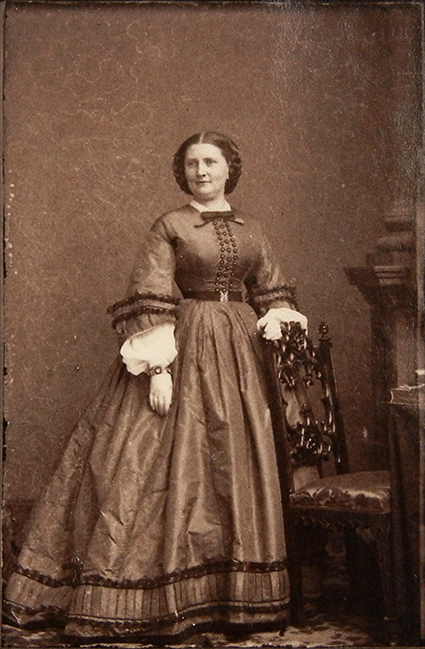 full length photo of a woman with her hand on a chair