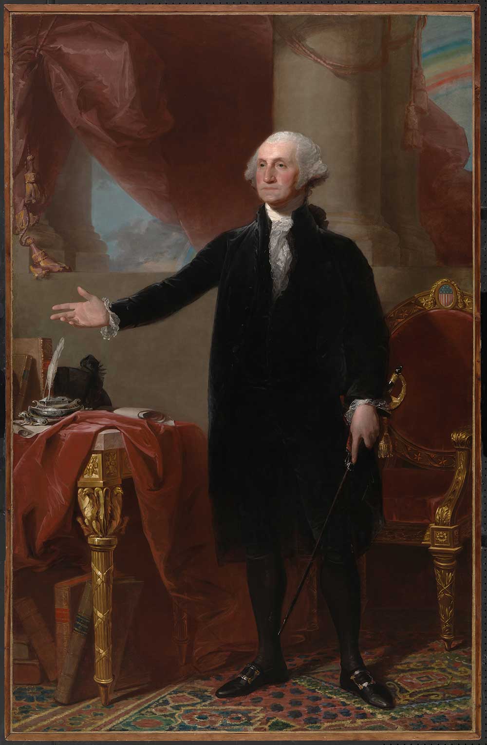 A full-length portrait of a man wearing a black suit staring to the right with his right hand extended