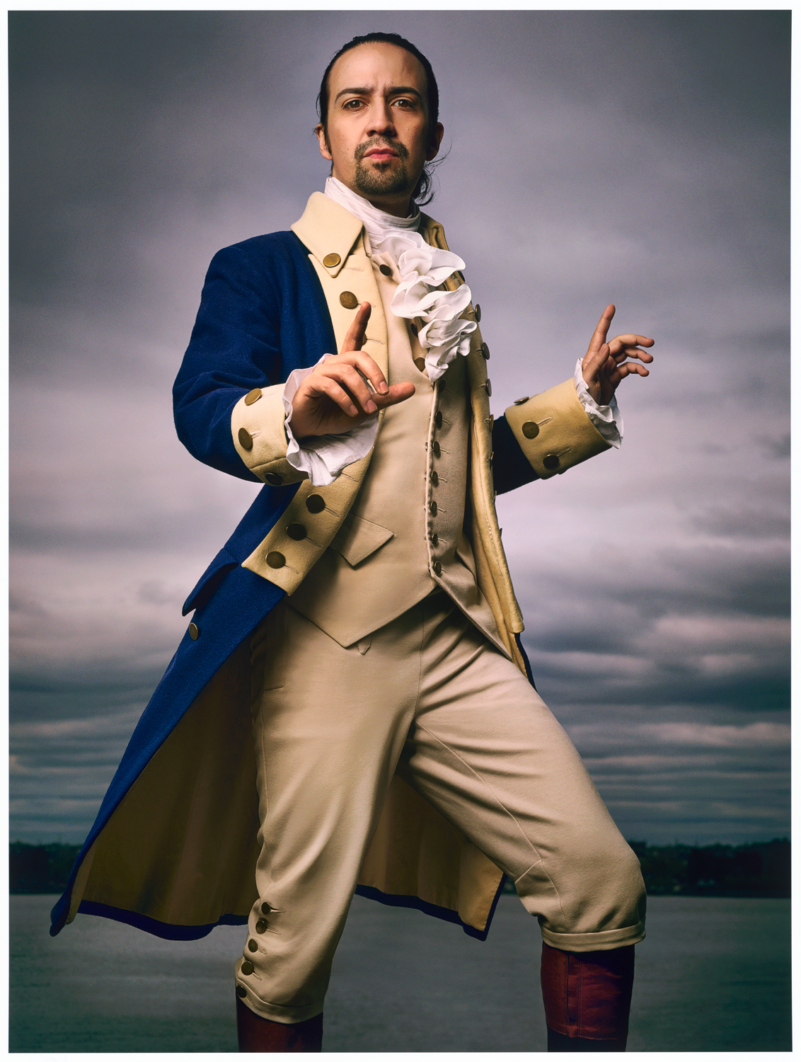 A man wearing colonial clothes and pointing at the camera