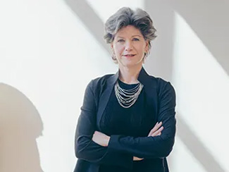 woman in a blue suit in a marble-walled gallery