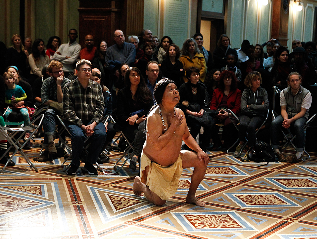 Man in Native American dress kneeling in the Great Hall