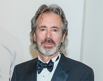 bearded man with gray hair in a tuxedo