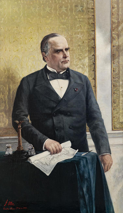 3/4 length portrait of a man in a suit holding documents