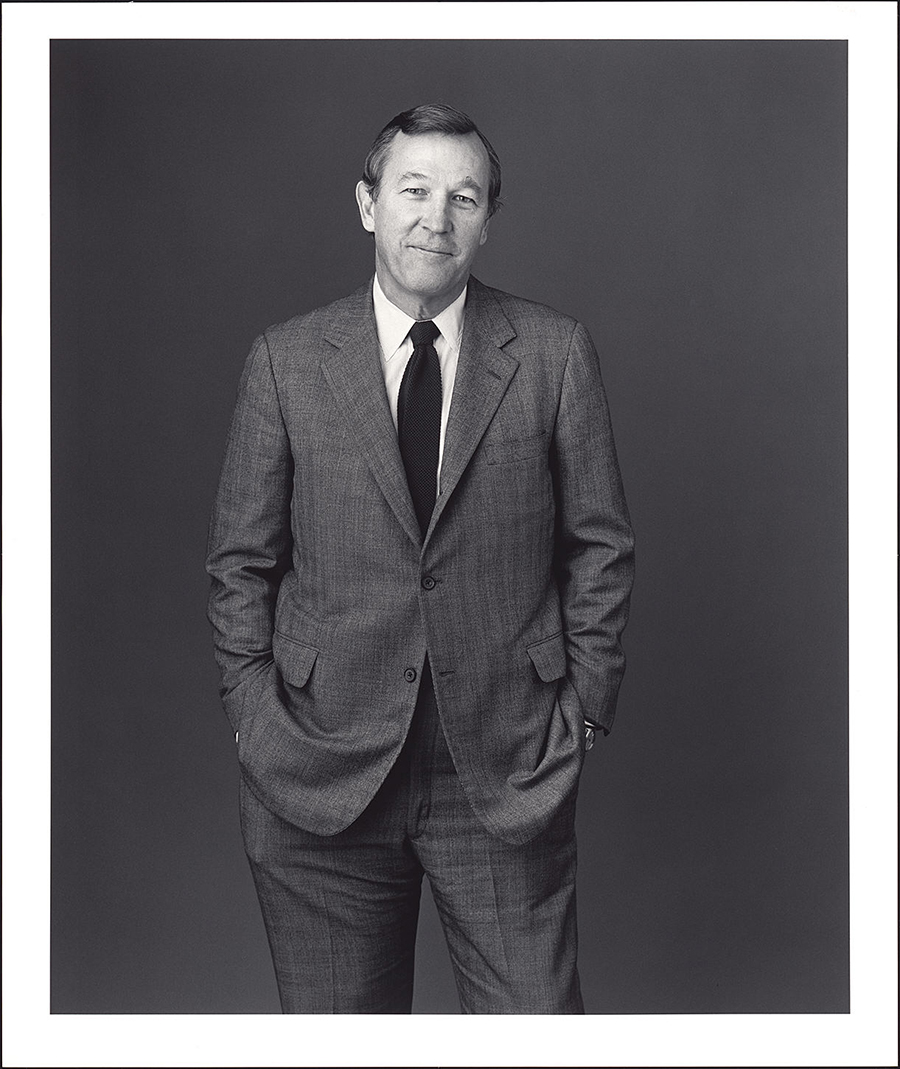 3/4 length view of a smiling man in a suit