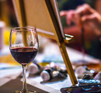 glass of wine near an easel