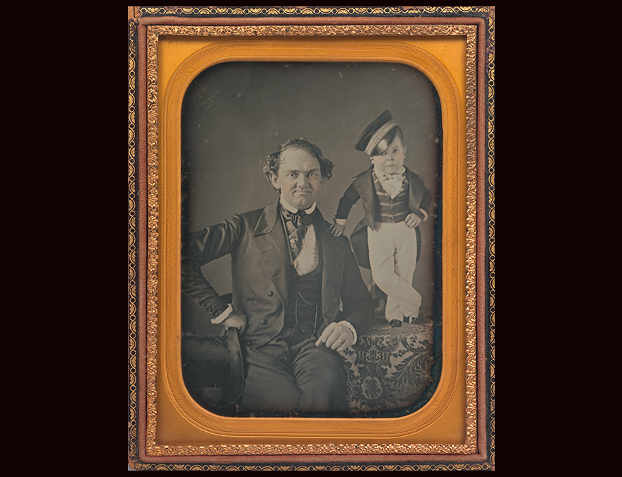 Daguerreotype of a seated man with a little person beside him