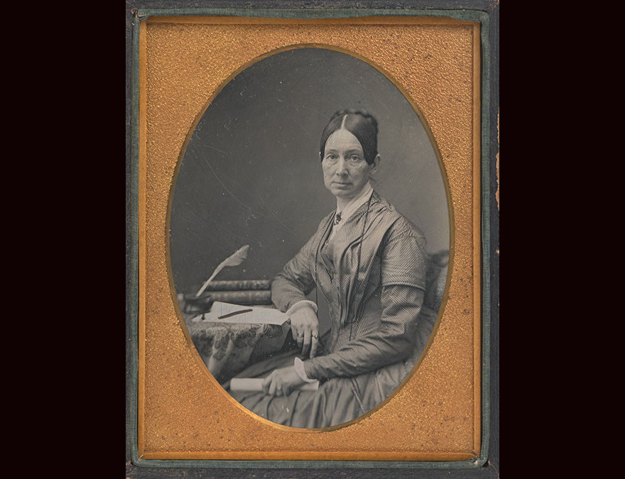 daguerreotype of a 19th century woman seated at a small table