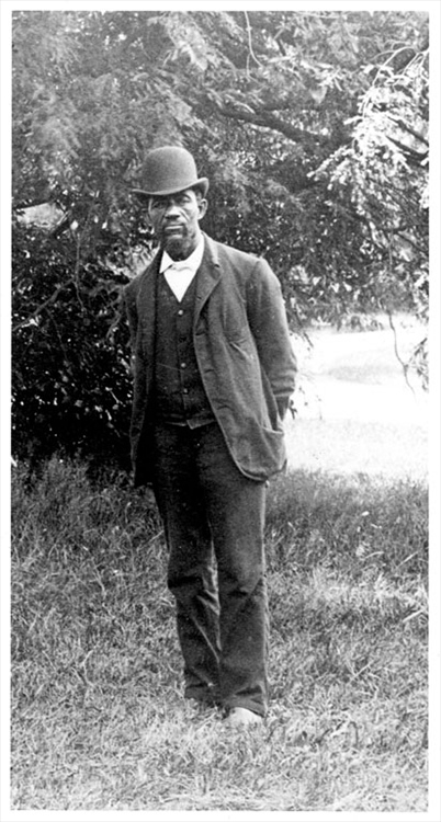 Full-length portrait of an African American man in a suit and bowler hat