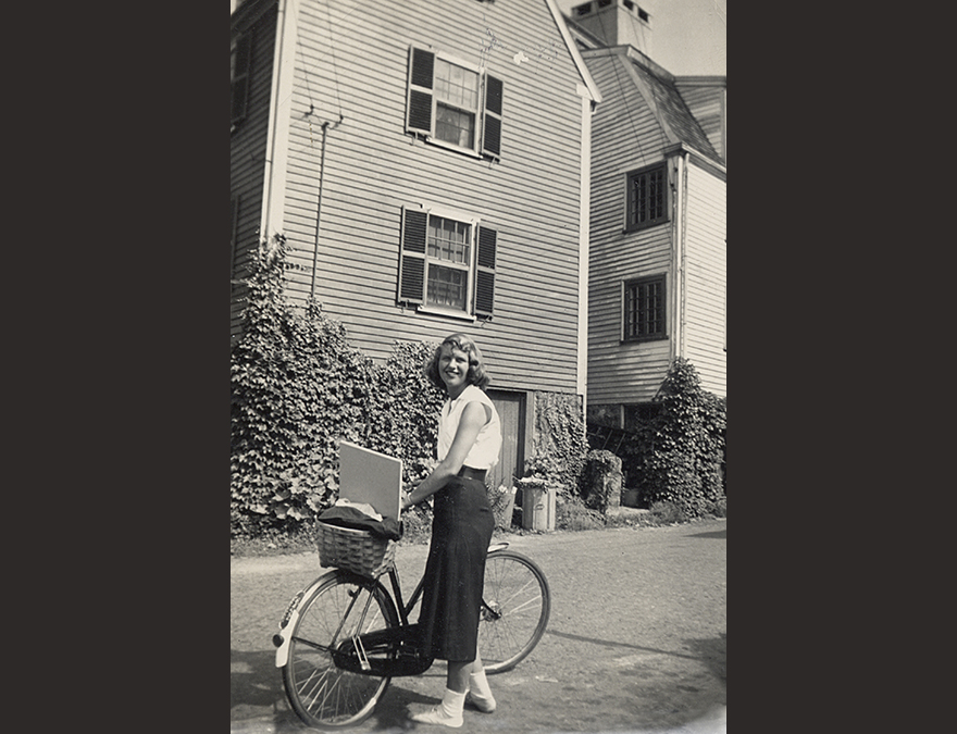 Woman with a bicycle outside a house