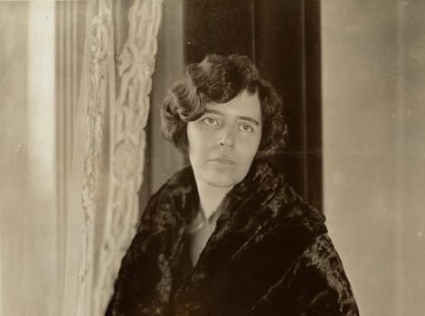 Black and white photograph of a woman in draped black clothing