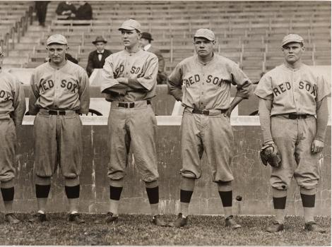 A black and white image of men wearing baseball uniforms standing in a row