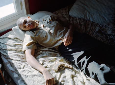 Photo of young man in ROTC uniform lying on bed