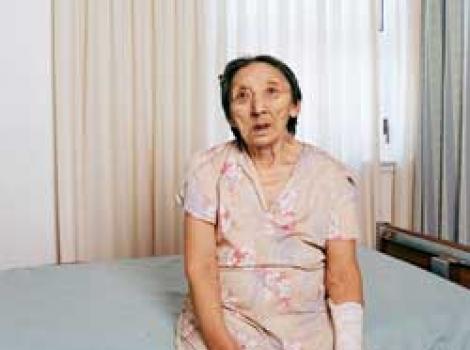 Portrait of elderly woman sitting on hospital bed