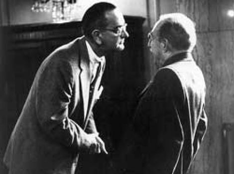 Black and white photo of Lyndon Johnson leaning intently towards Theodore Green