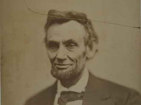 Photograph of Lincoln -- the photo is cracked, with thin crack from left corner through top of Lincoln's head