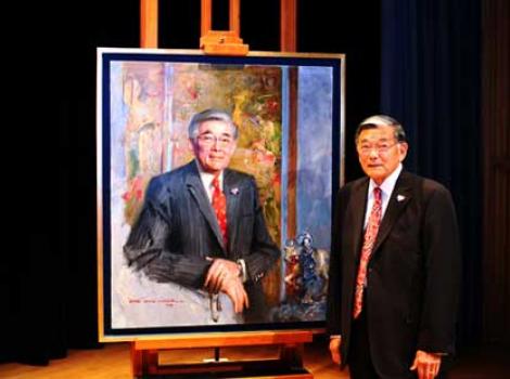 Norm Mineta on stage, next to his portrait