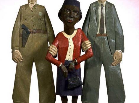 Wood sculpture of Rosa Parks being arrested by two white policemen