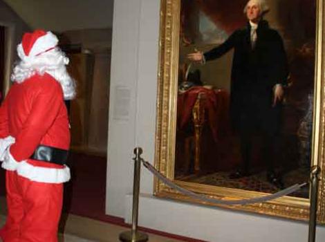 Man in santa suit looking at George Washington portrait in the museum galleries