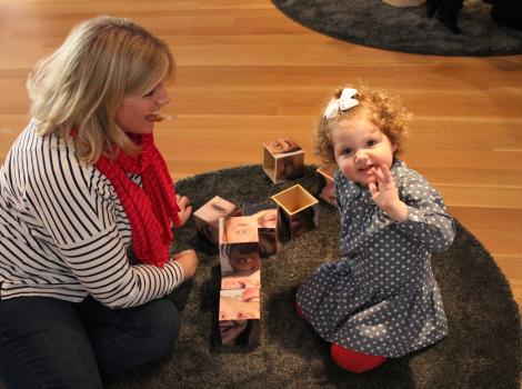 A mother and daughter sitting on the floor and playing with blocks