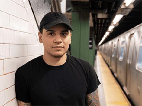 Young man in a black shirt standing in a subway station