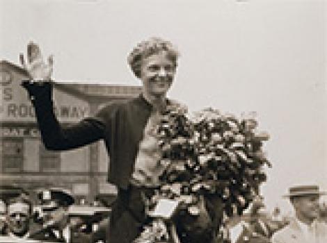Amelia Earhart waving to a crowd