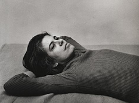 Susan Sontag lying on a bed with her hands behind her head