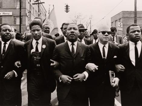 group of men marching arm in arm
