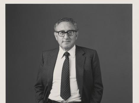 knee length photo of a man in a suit with glasses