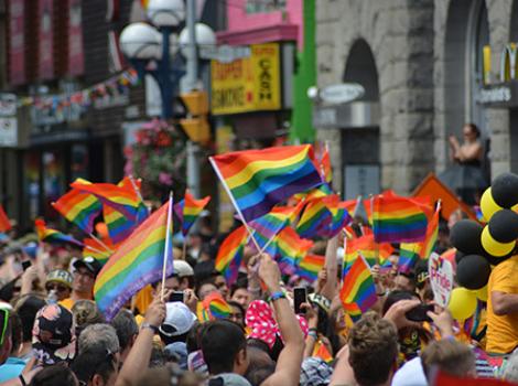 Colorful Gay Pride march with people waving flags