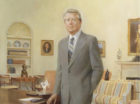 Full length portrait of a man standing by a desk