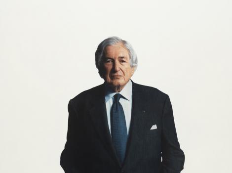3/4 length view of a gray-haired man in a suit