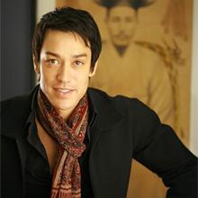 waist length photo of a young Asian man in a black sweater and patterned scarf