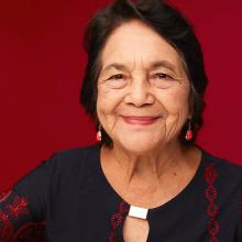 Smiling woman in a black and red dress against a red background