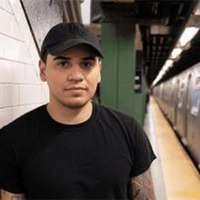 Young man in a black shirt standing in a subway station