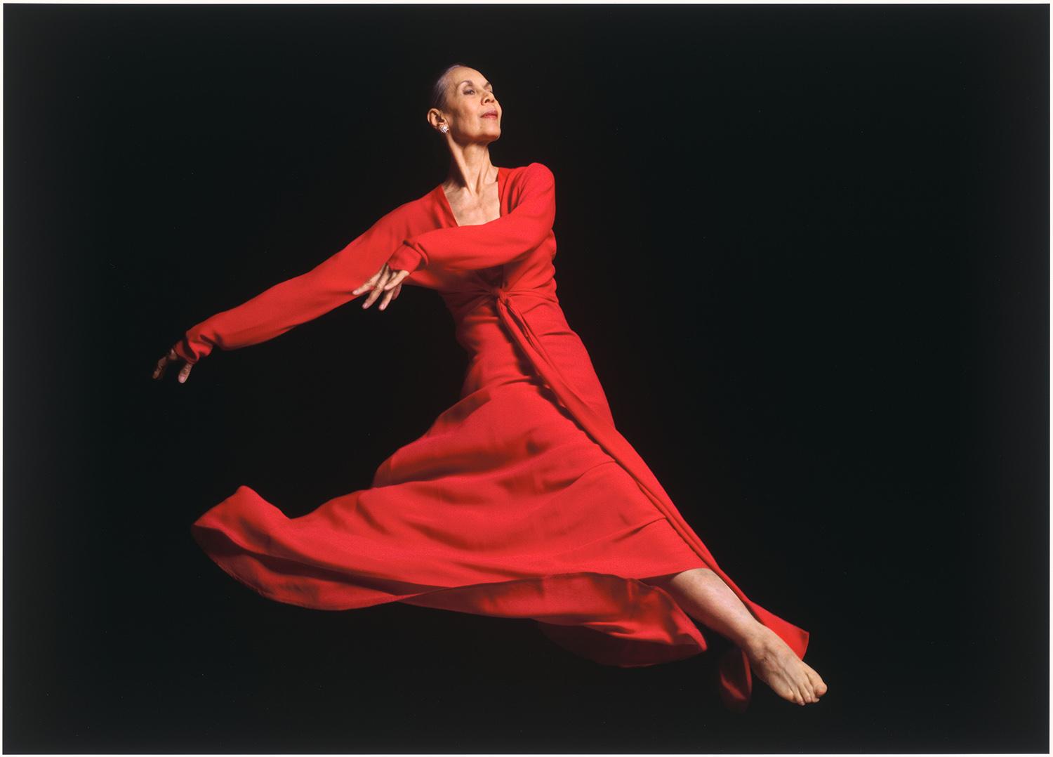 dancer in a red dress against a black background