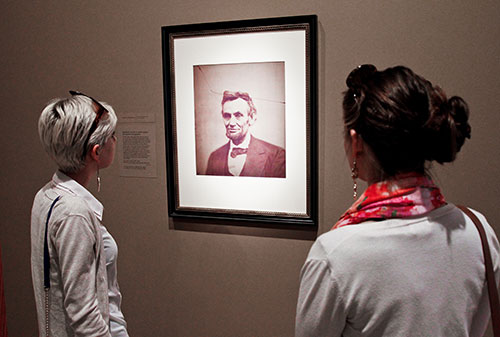 Two visitors looking at portrait of LIncoln