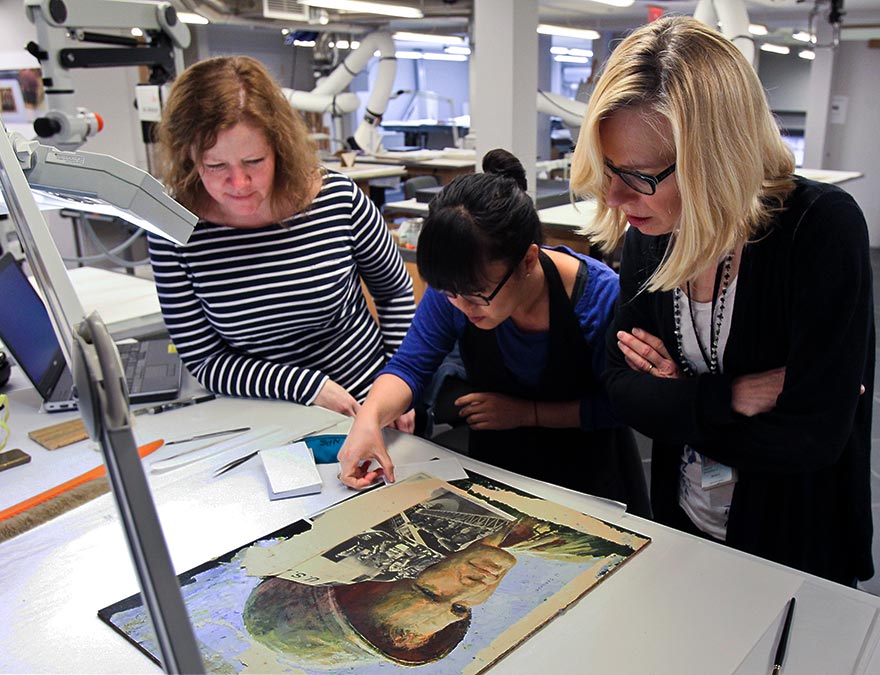 Conservators perform  an initial  examination of a painting scheduled for treatment.