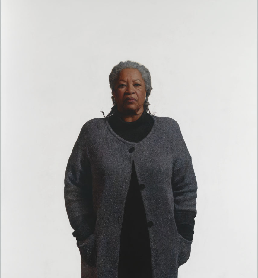 African American woman in a gray sweater standing against a white background