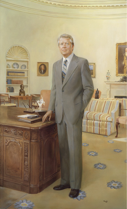 Full length portrait of a man standing by a desk